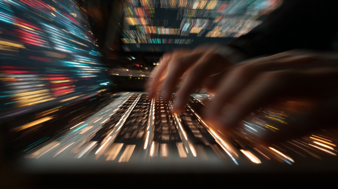 Hands typing on a keyboard with motion blur and streaks of digital data