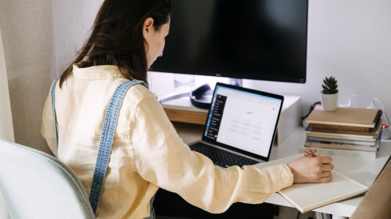 Blogger usеs ChatGPT tools on a laptop to plan and write content at a home desk