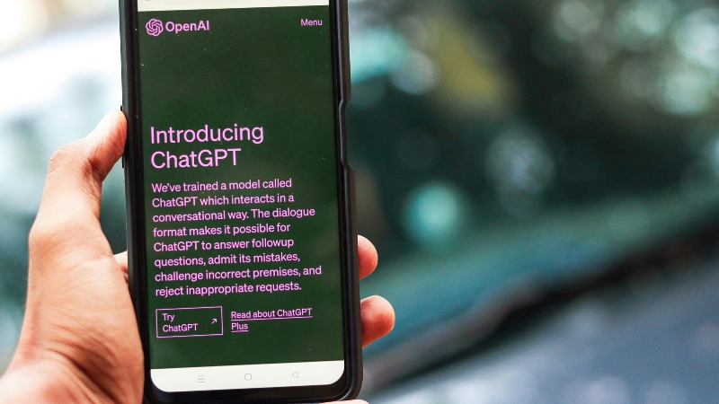 A person holds a phone screen showing ChatGPT used for blog website SEO writing