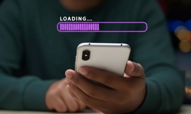 A person holding a cell phone displaying a loading screen