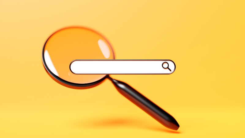 A magnifying glass behind a search bar on a yellow background