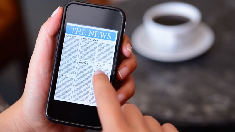 A person scrolls through a news article on a smartphone screen