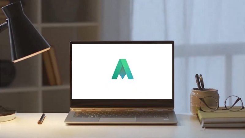 Laptop on a desk displaying a green AdSense-style logo on the screen